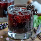 A close-up of deep ruby Black Currant Rum Liqueur, its rich berry notes captured in a chilled glass.
