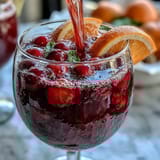 A colorful party punch featuring scoops of sherbet and bubbling Sprite, garnished with fresh citrus slices for festive flair.