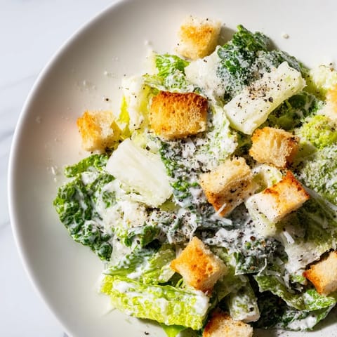 Crisp romaine lettuce in creamy Caesar salad, topped with Parmesan and crunchy croutons.